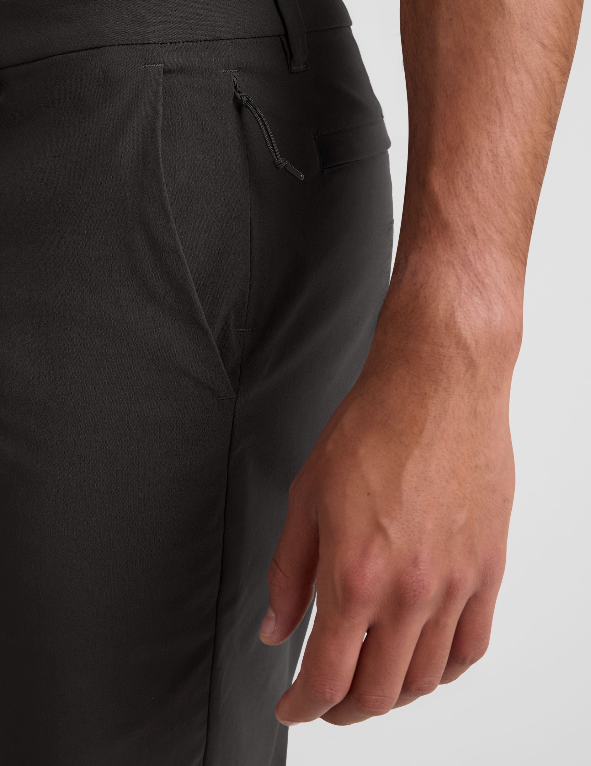 Side view of the black Essential Men's Chino 30" Trouser showing tailored side pockets and a hidden zipper pocket detail.