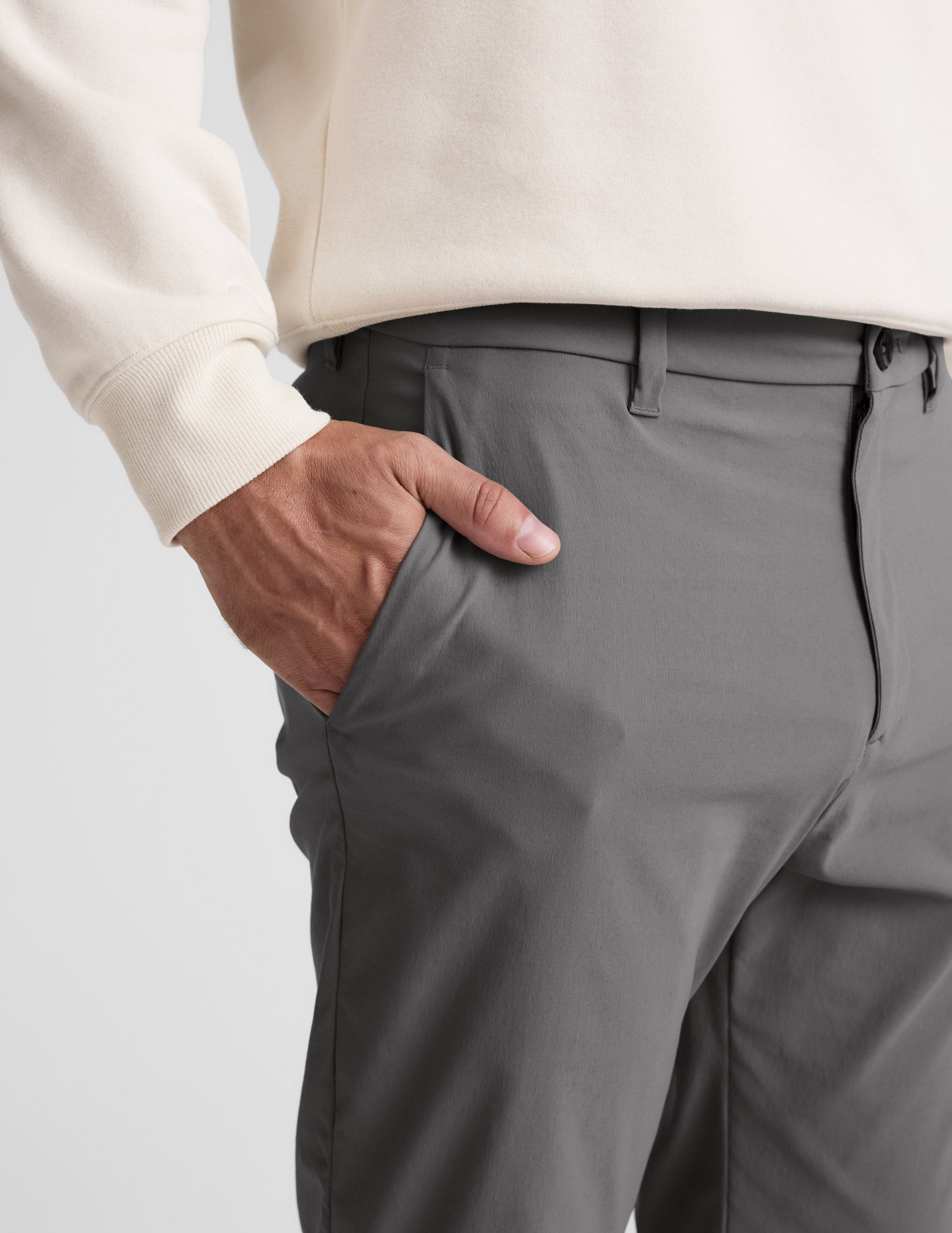 Close-up of gray Element Men's Chino Trouser showing a hand in the side slant pocket, waistband, and belt loops.