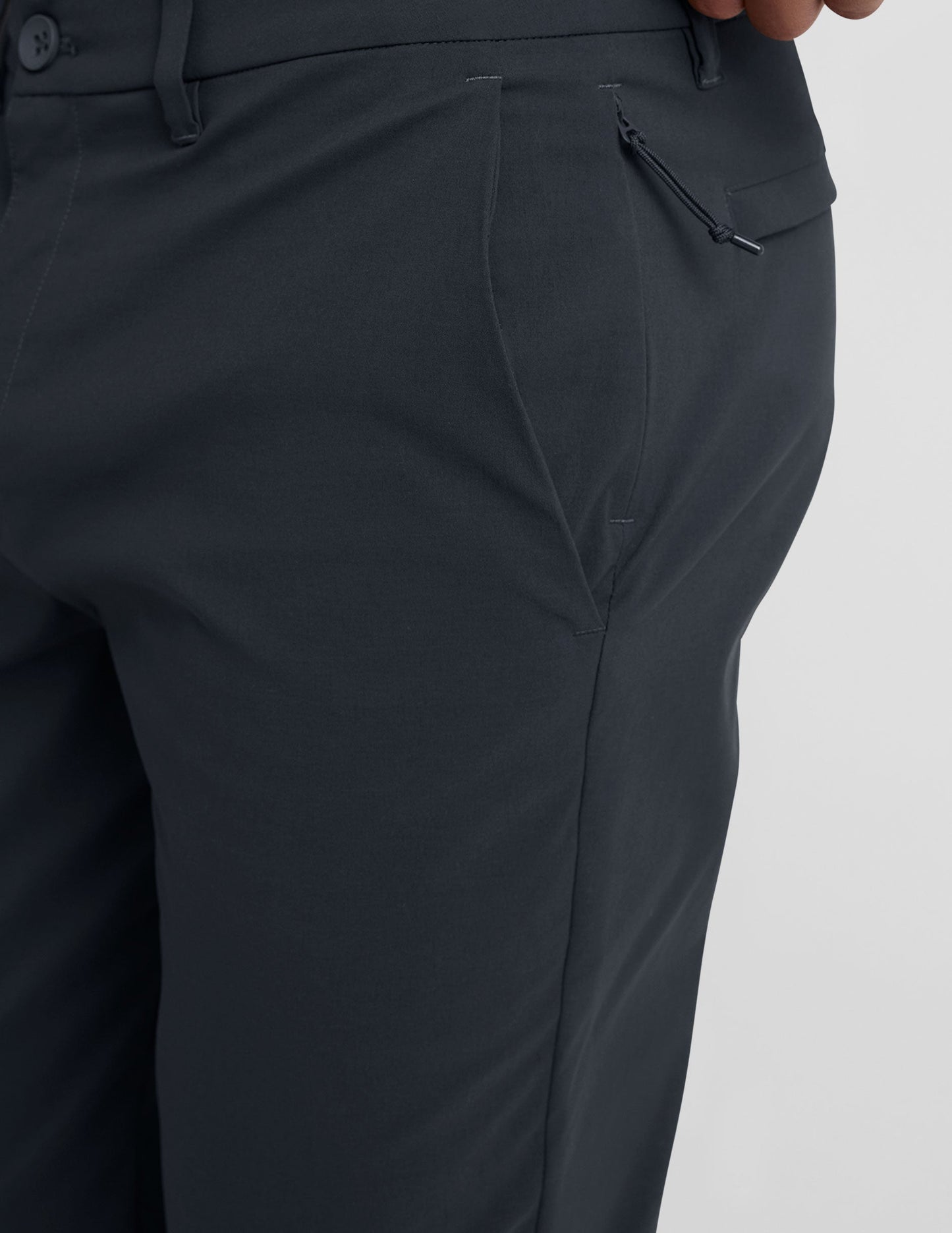 Close-up of Essential Men's Chino 30" Trouser in dark gray featuring belt loops, slant pocket, and side zipper detail.