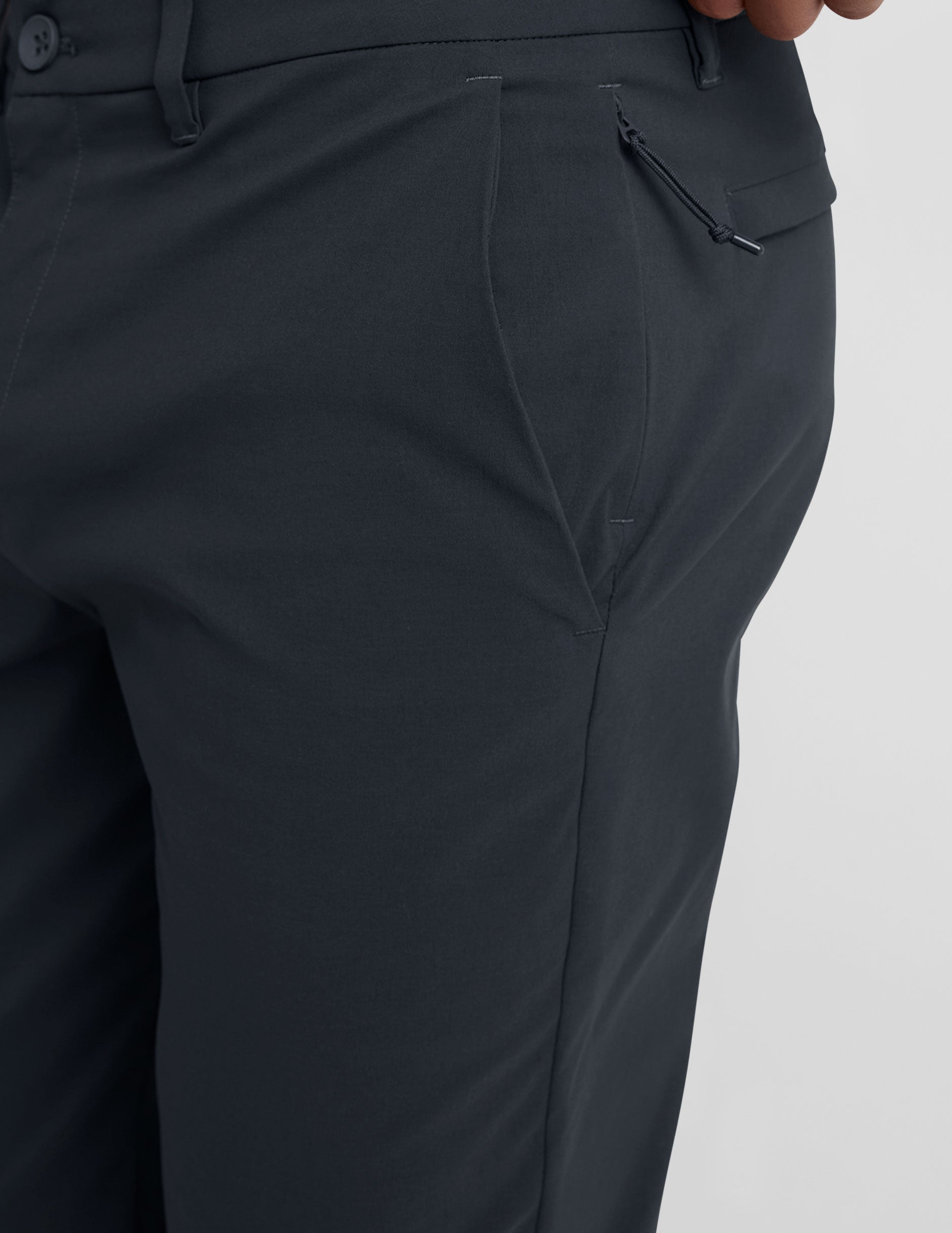 Close-up of Essential Men's Chino 30" Trouser in dark gray featuring belt loops, slant pocket, and side zipper detail.