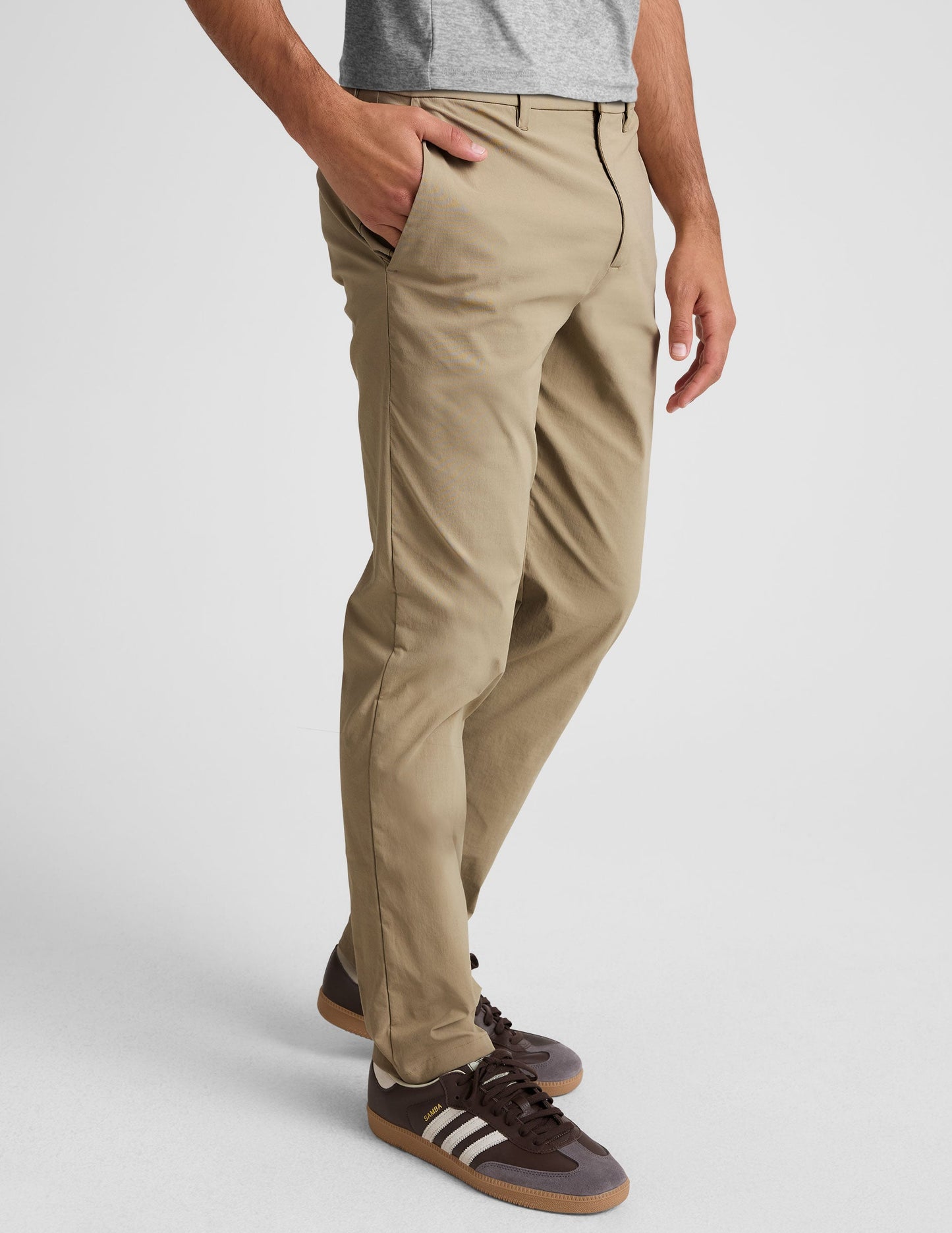 Side view of beige Essential Men's Chino 32" Trouser on a model, featuring a straight leg fit and side hand pockets.