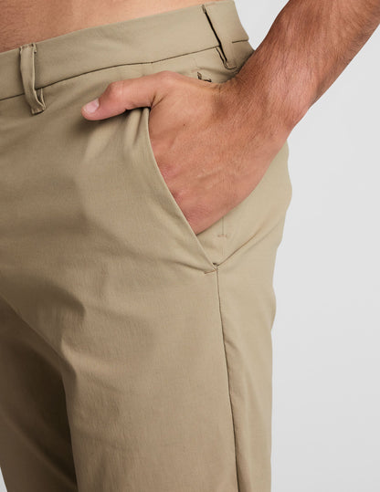 Close-up of beige Essential Men's Chino 32" Trouser showing side pocket and belt loop details on a man's hip.