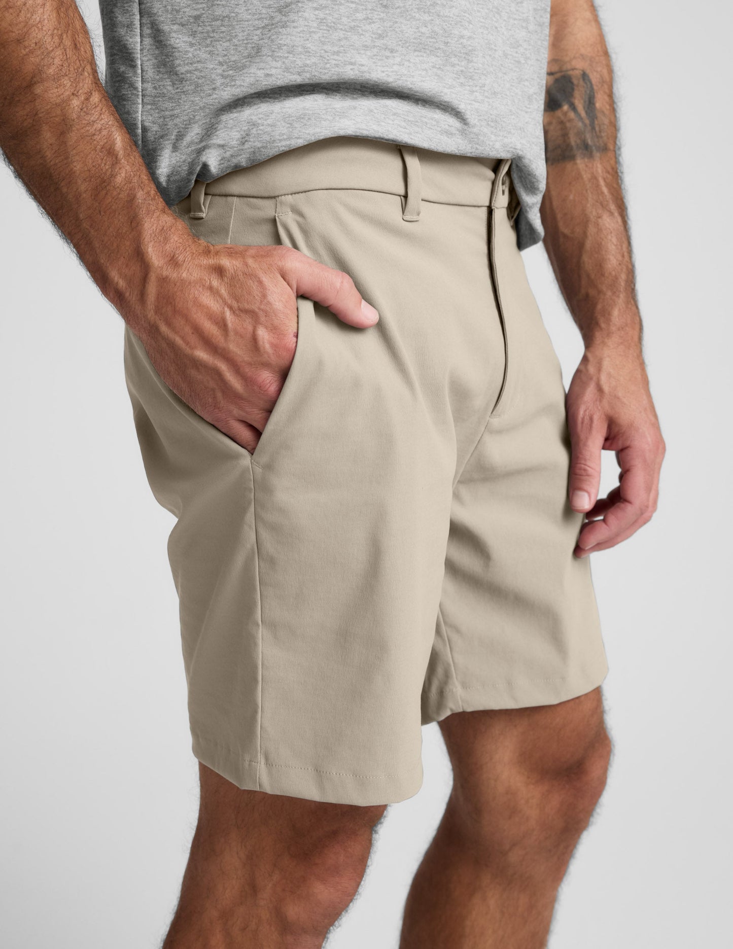 Side view of beige Element Men's Chino Short 7" on model, showing hand pocket, belt loops, and tailored mid-thigh fit.