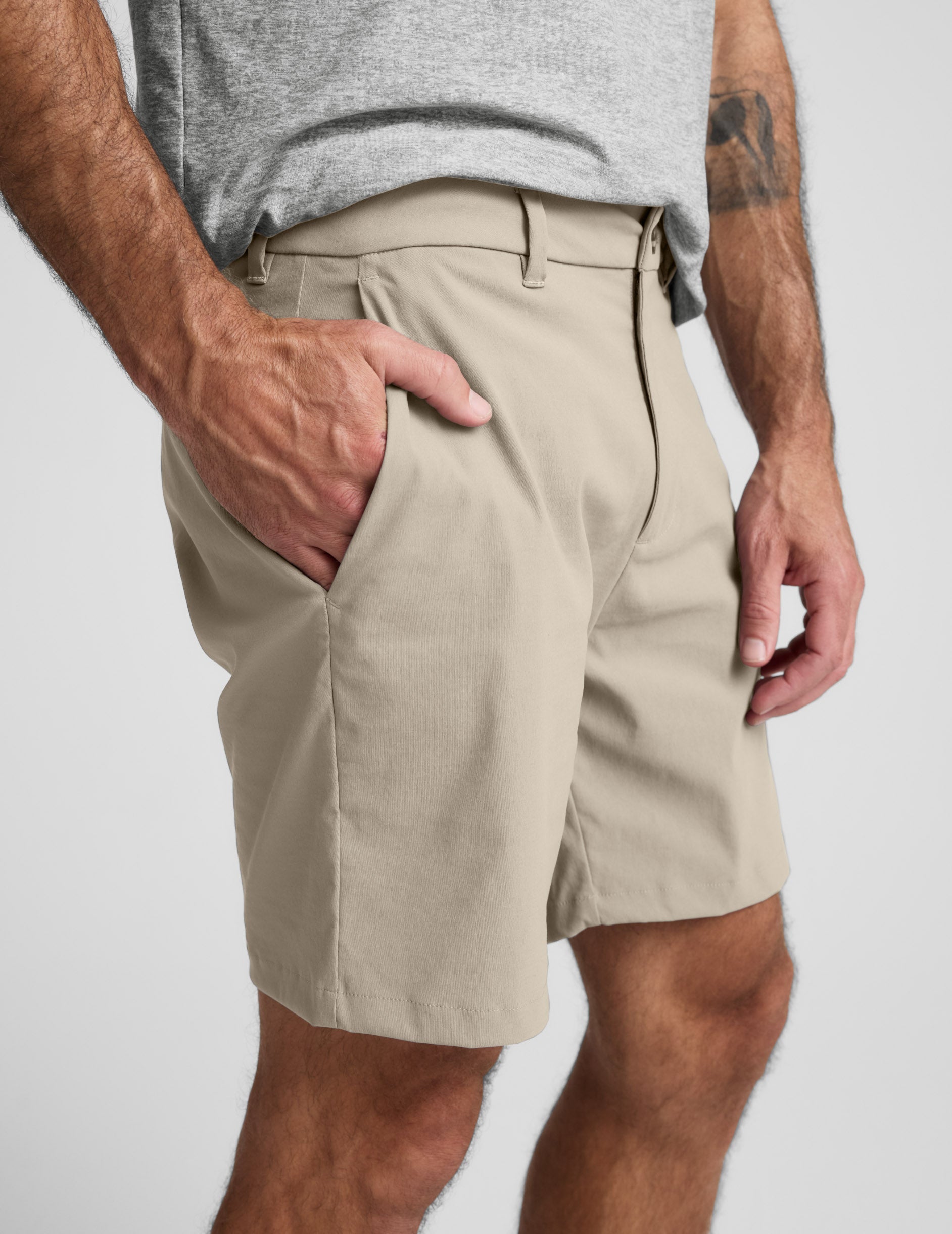 Side view of beige Element Men's Chino Short 7" on model, showing hand pocket, belt loops, and tailored mid-thigh fit.