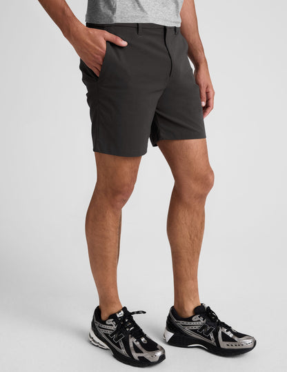 Essential Men's Chino 7" Short in dark grey on a model, featuring a regular fit, belt loops, and mid-thigh length.