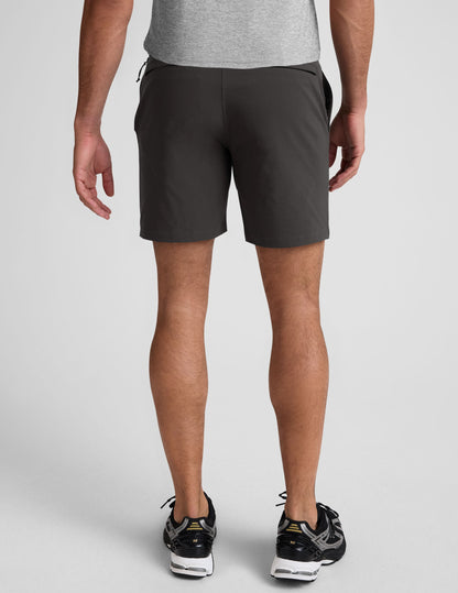 Rear view of a man wearing black Essential Men's Chino 7" Shorts with belt loops and two back welt pockets.