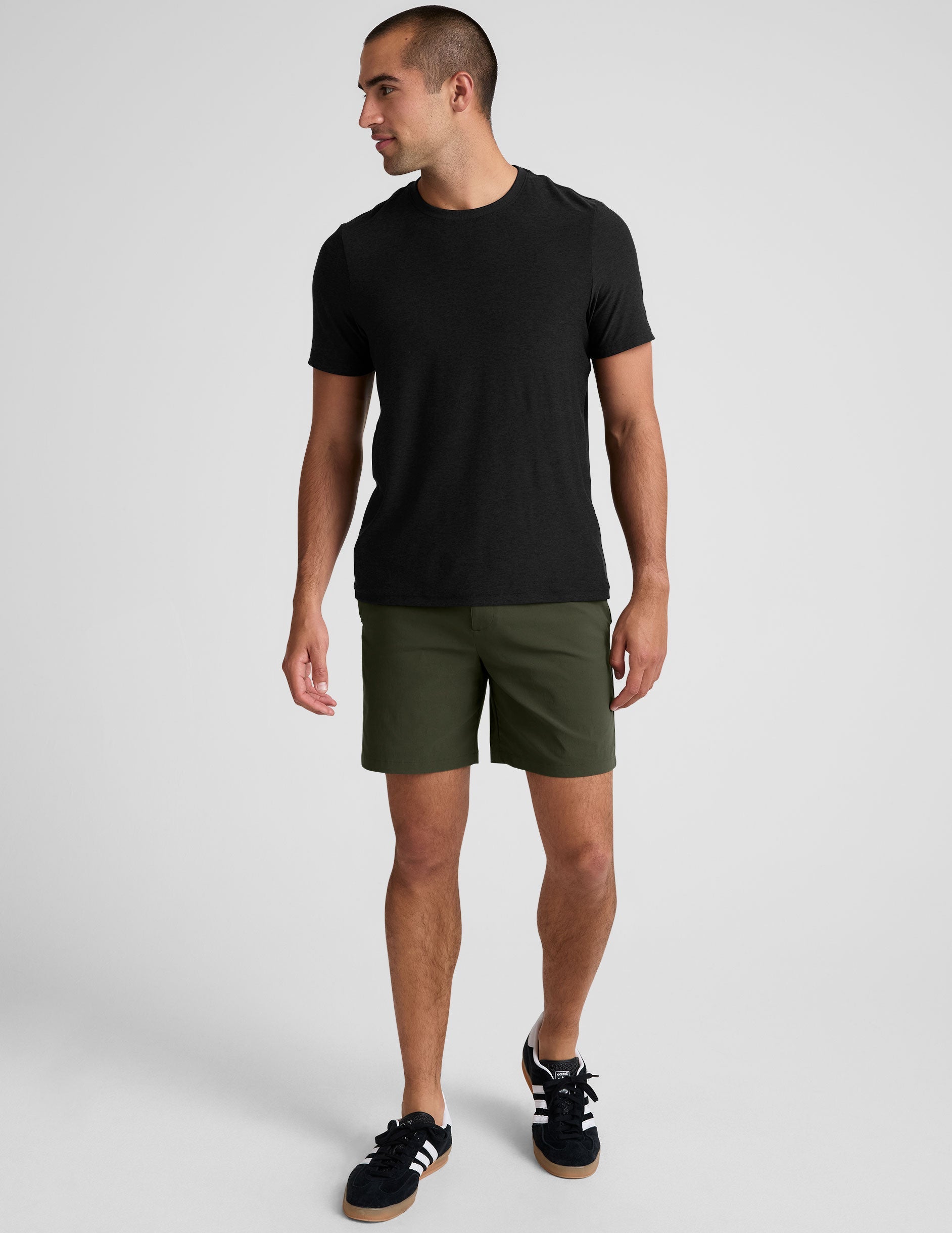 Essential Men's Chino 7" Short in olive, featuring a straight leg, mid-thigh length, and side pockets on a model.