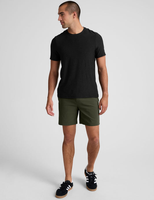 Essential Men's Chino 7" Short in olive, featuring a straight leg, mid-thigh length, and side pockets on a model.