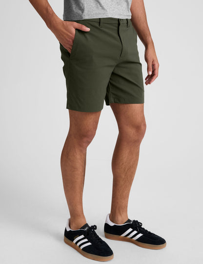 Olive green Essential Men's Chino 7" Short on a model, featuring a tailored mid-thigh length and side hand pockets.