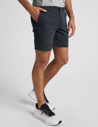 Side view of charcoal Essential Men's Chino 7" Short on a model, featuring side pockets and a mid-thigh length.