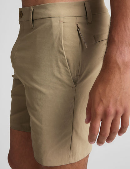 Essential Men's Chino 7" Short in beige, side view showing the waistband, belt loops, pockets, and hidden zipper.
