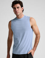Man wearing a blue tank and black shorts against a plain background.