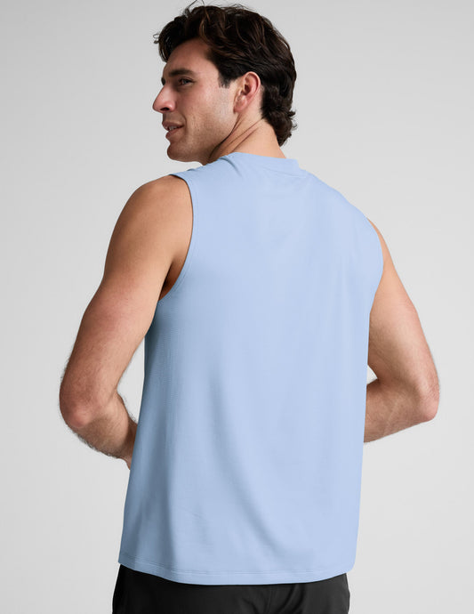 Man wearing a blue tank and black shorts against a plain background.