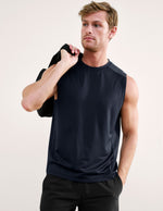 Man wearing a blue sleeveless shirt against a light background.