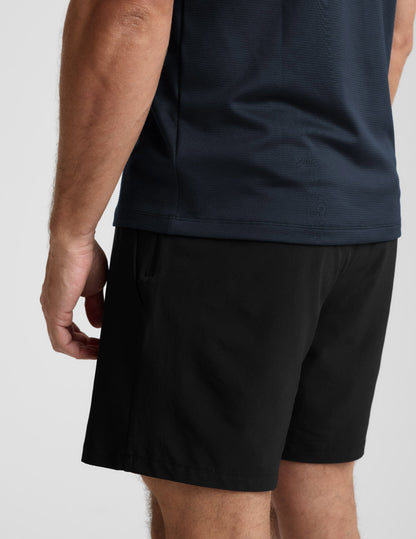 Person wearing black shorts and a dark shirt on a light gray background
