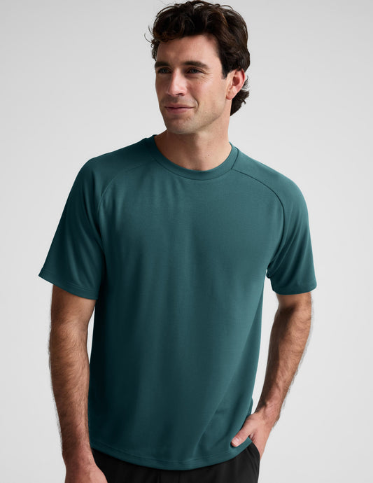 Man wearing a teal t-shirt against a plain background.