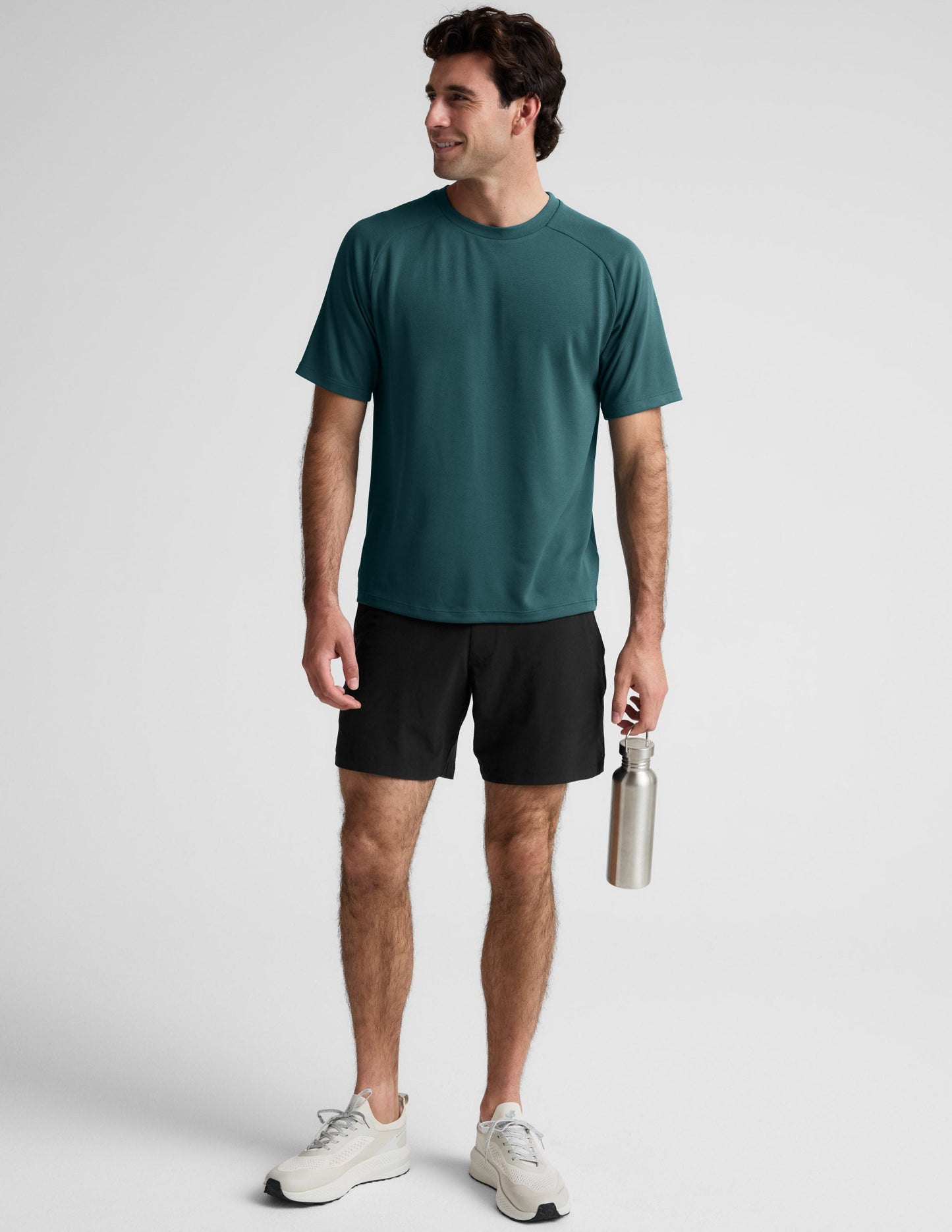 Man wearing a teal t-shirt against a plain background.