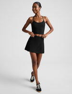 Woman wearing Black marled Midweight Spacedye Kickstart Skirt paired with a matching tank top and black sneakers.