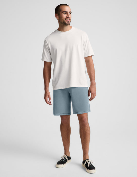 Man wearing blue Beach Washed Terry™ Men's Short paired with a white t-shirt and black sneakers.