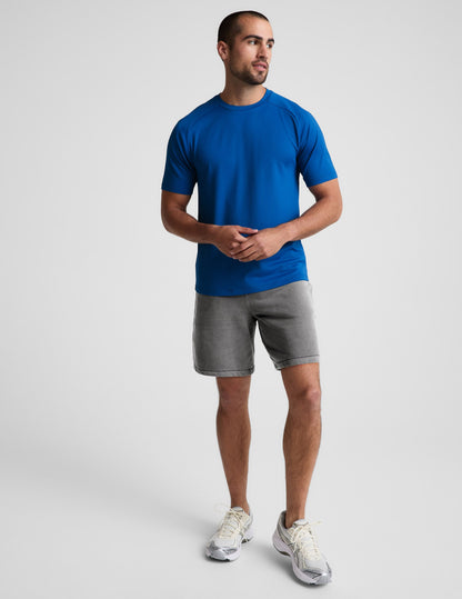Man wearing Gray Beach Washed Terry Men's Short with a blue t-shirt and cream sneakers.