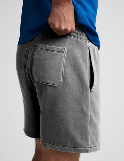 Man wearing Gray Beach Washed Terry Men's Short™ with a blue shirt, rear view showing back patch pocket and side pocket.