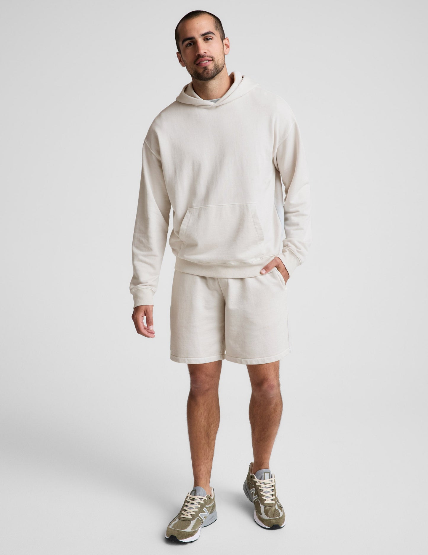 Man wearing Cream Beach Washed Terry Men's Short™ paired with a matching cream hoodie and olive sneakers.