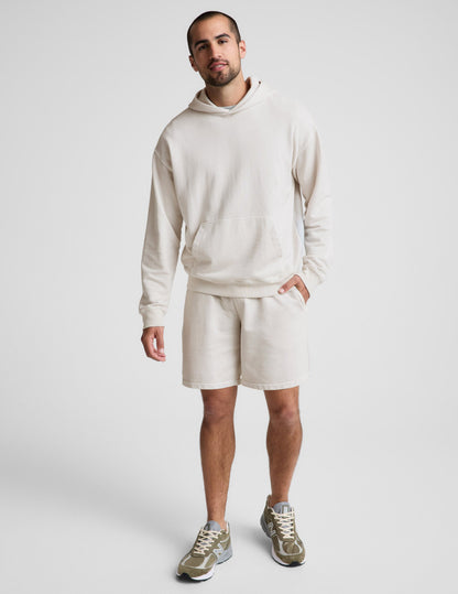 Man wearing Cream Beach Washed Terry Men's Short™ paired with a matching cream hoodie and olive sneakers.