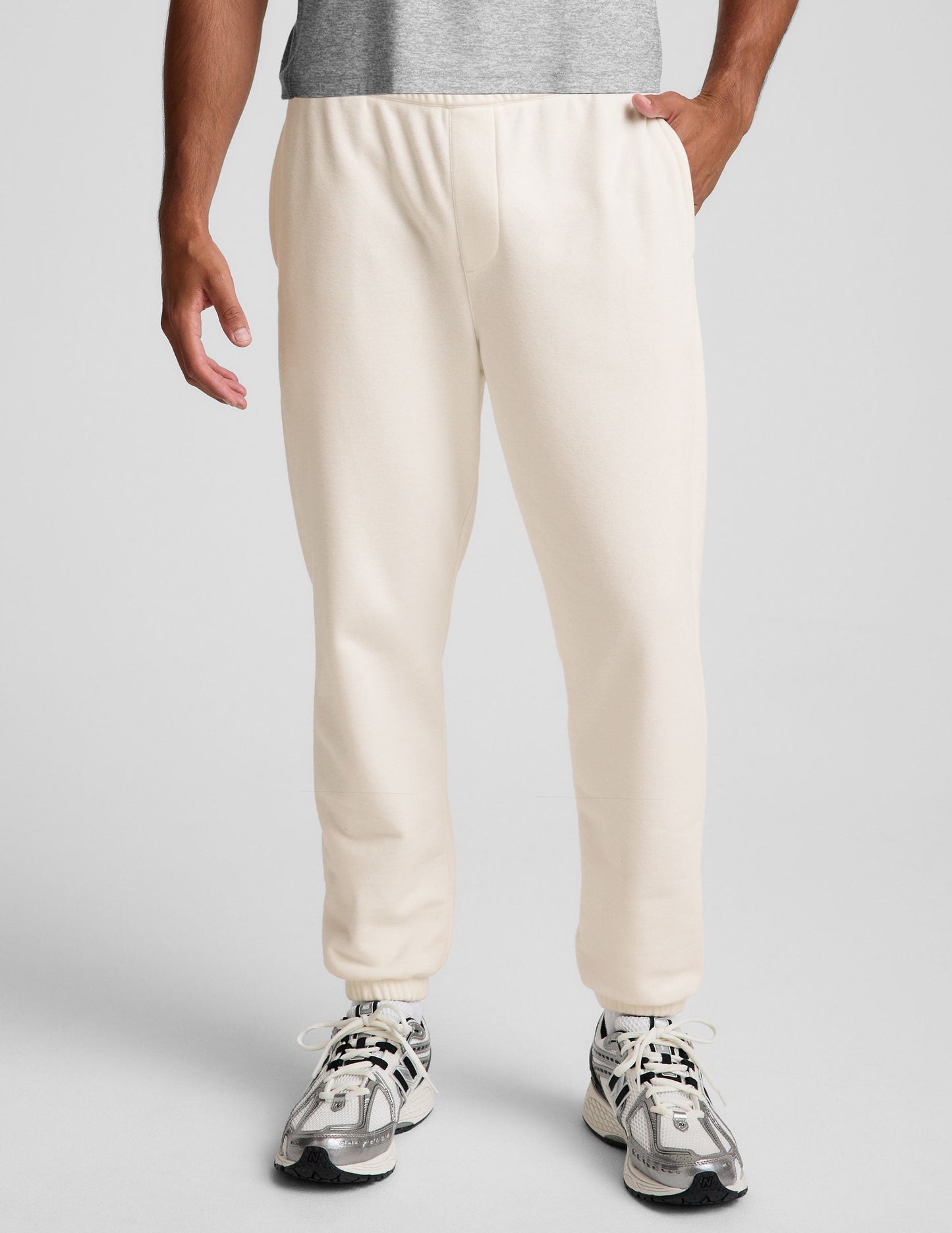 Off-white Classic Fleece Men's Jogger featuring an elastic waistband, side pockets, and gathered cuffs on a model.