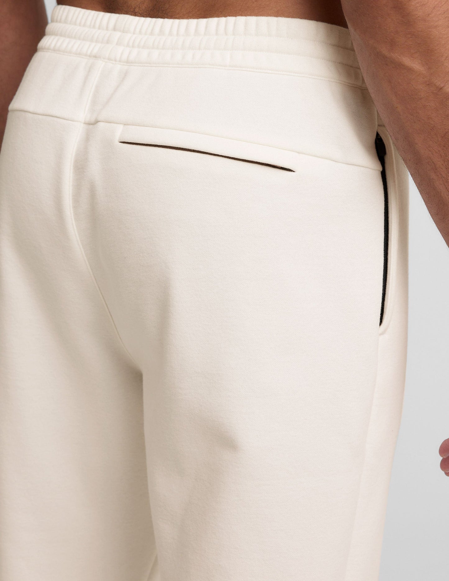 Back view of Classic Fleece Men's Jogger in light gray showing the elastic waistband, back welt pocket, and side zipper.