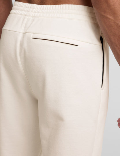 Back view of Classic Fleece Men's Jogger in light gray showing the elastic waistband, back welt pocket, and side zipper.