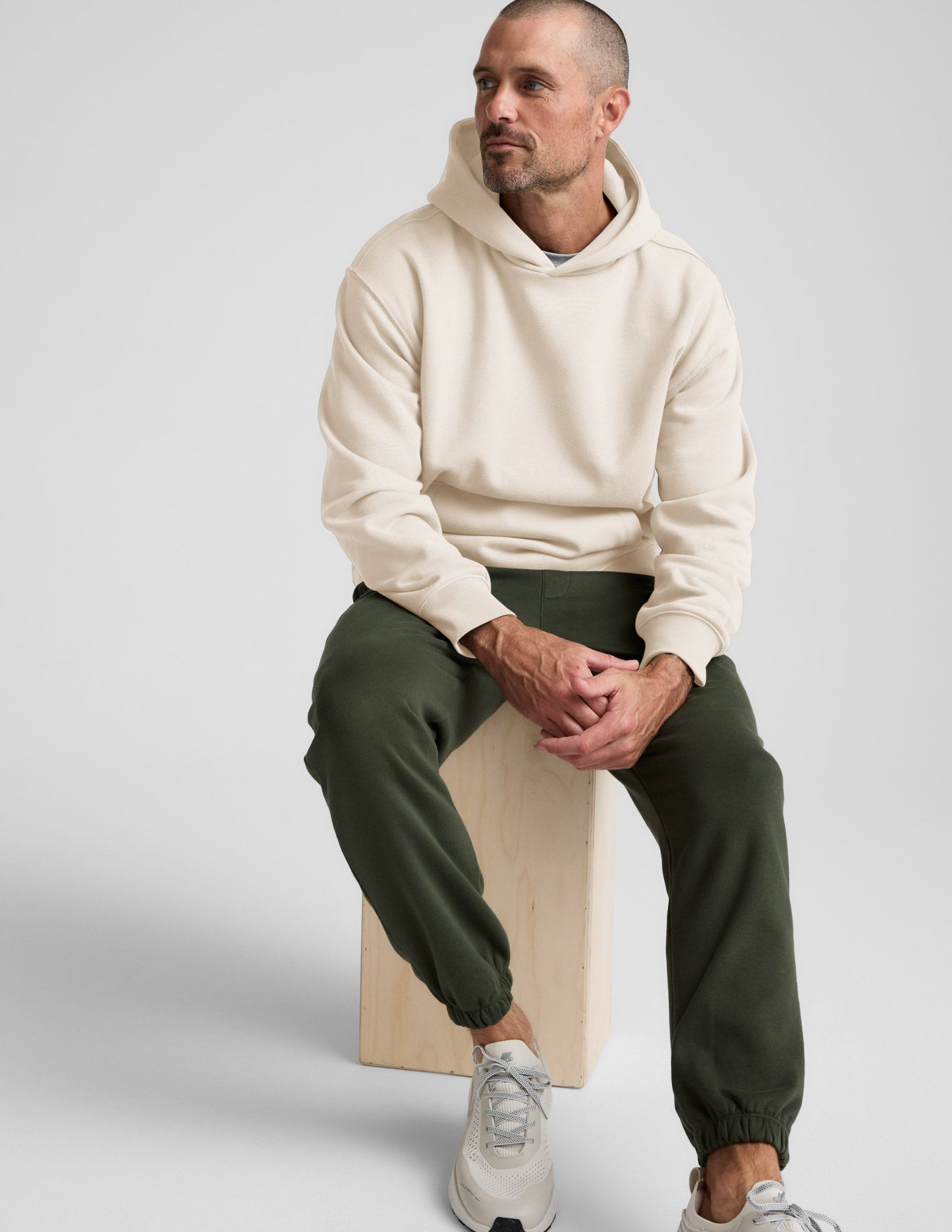 Navy Classic Fleece Men's Jogger worn by a man with a cream hoodie and grey sneakers.