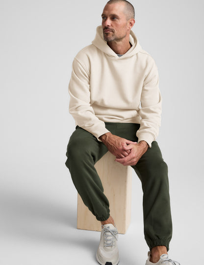 Navy Classic Fleece Men's Jogger worn by a man with a cream hoodie and grey sneakers.