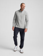 Man walking in dark gray Classic Fleece Men's Joggers with elastic cuffs, paired with a light gray quarter-zip pullover.