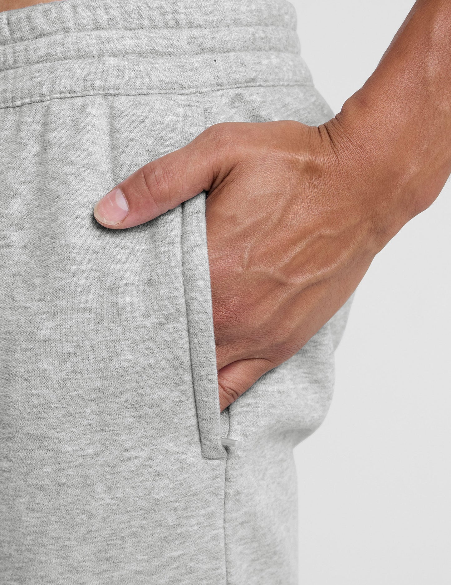 Gray LuxeFleece Men's Straight Leg Pant close-up showing marled fabric, elastic waist, and hand in zippered pocket.