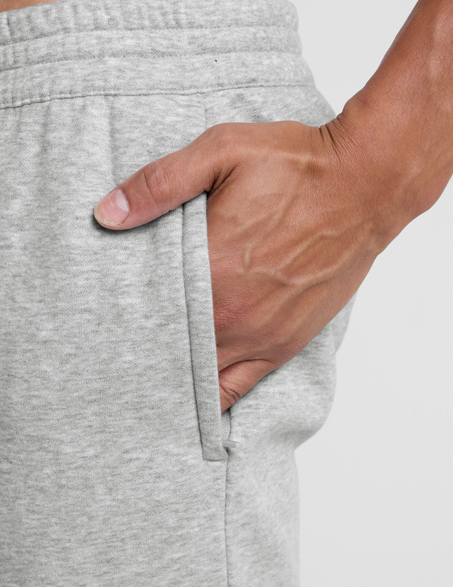 Gray LuxeFleece Men's Straight Leg Pant close-up showing marled fabric, elastic waist, and hand in zippered pocket.