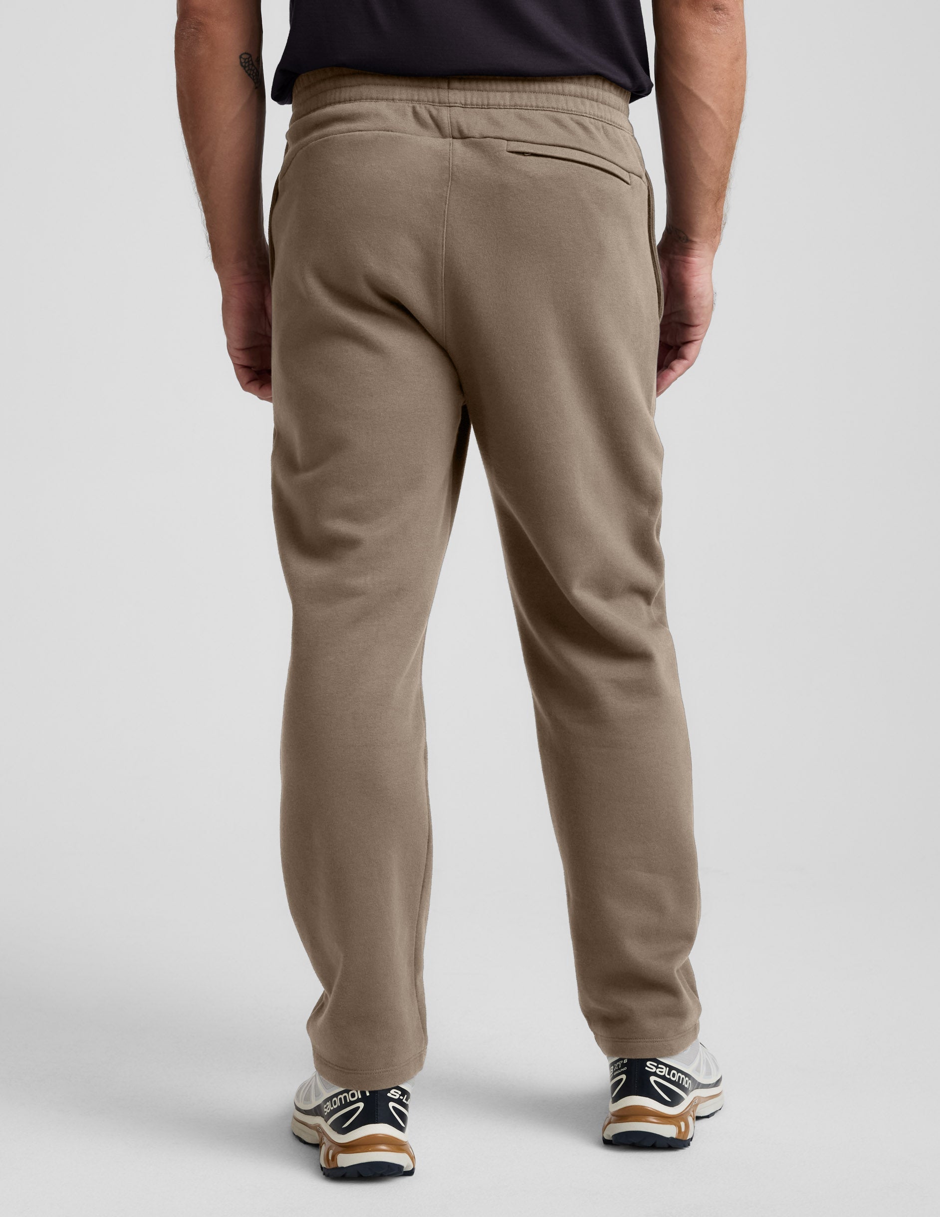 Rear view of brown LuxeFleece Men's Straight Leg Pant featuring an elastic waistband and zippered back welt pocket.