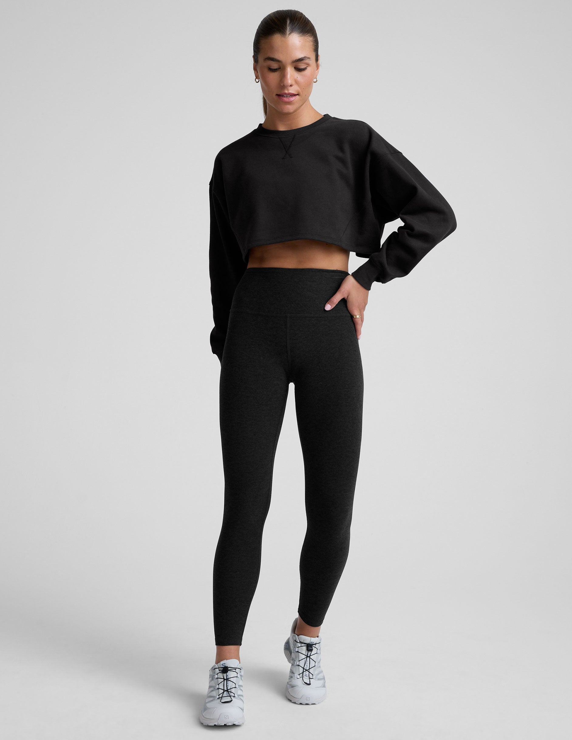 model wearing a black boxy fit cropped sweatshirt against a plain background.