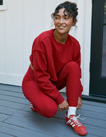 Woman in red outfit on a wooden deck.