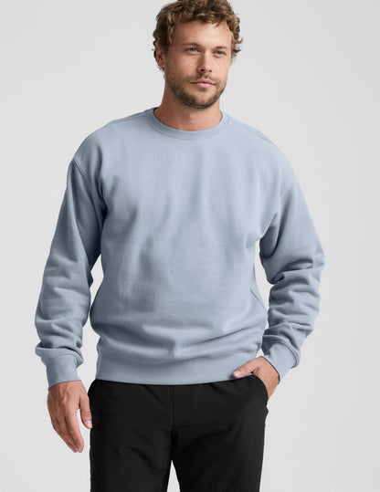 Man wearing a light blue sweatshirt against a plain background.