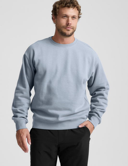 Man wearing a light blue sweatshirt against a plain background.
