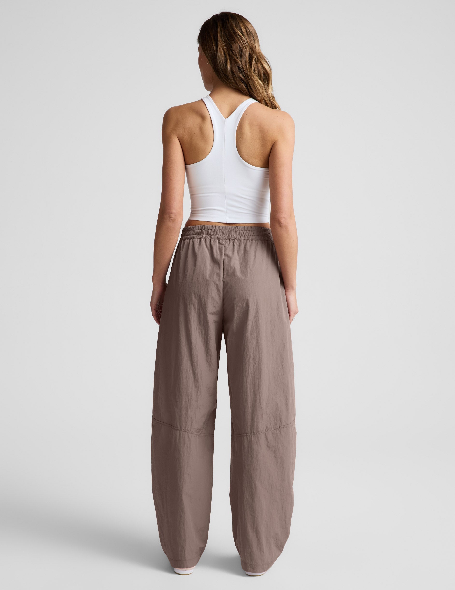 Rear view of brown Limitless Mid-Rise Barrel Leg Pant with a gathered elastic waist and a relaxed, barrel-leg silhouette.