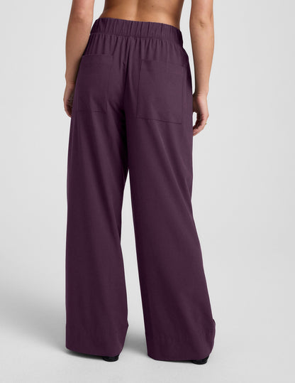 Rear view of woman wearing Plum Easy Wide Leg Pant 29"™ with bare back, back pockets, and gathered elastic waistband.