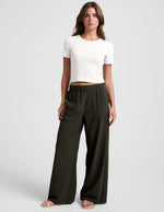 Model wears dark green Easy Wide Leg Pant featuring a flowy relaxed fit, elastic waistband, and front pockets.
