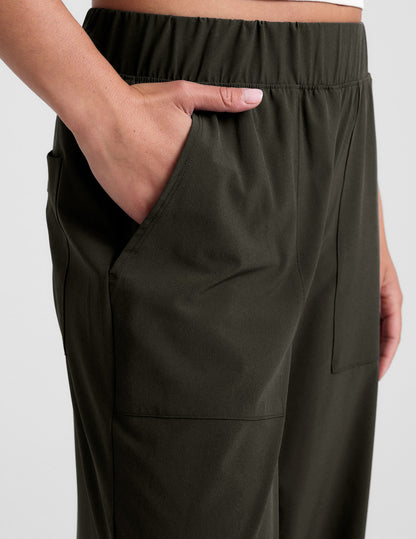 Close-up of the dark green Easy Wide Leg Pant with an elastic waistband and a hand resting in the side seam pocket.