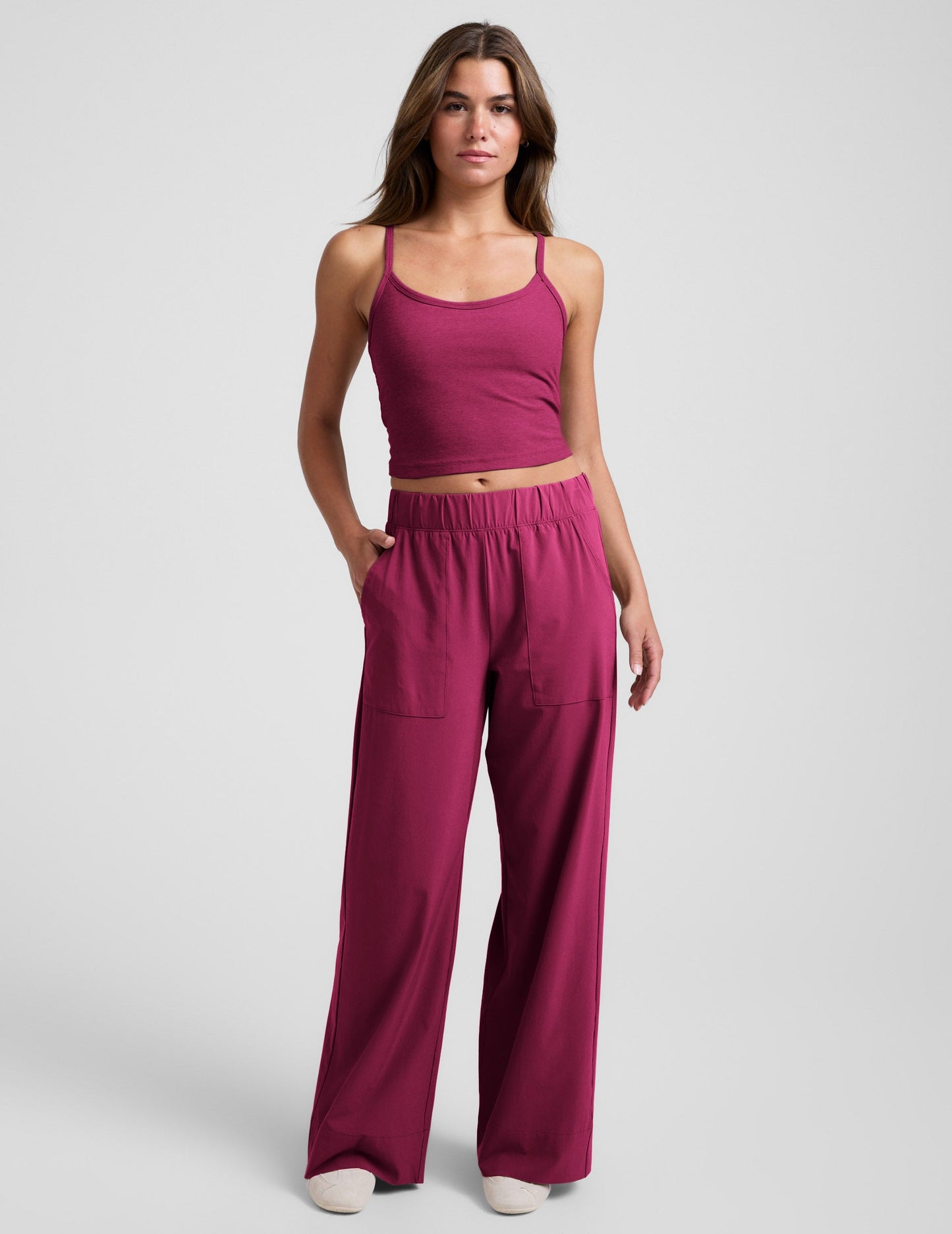 Woman wearing Maroon Beyond Yoga™ Easy Wide Leg Pant 31" paired with a matching tank top and sneakers.