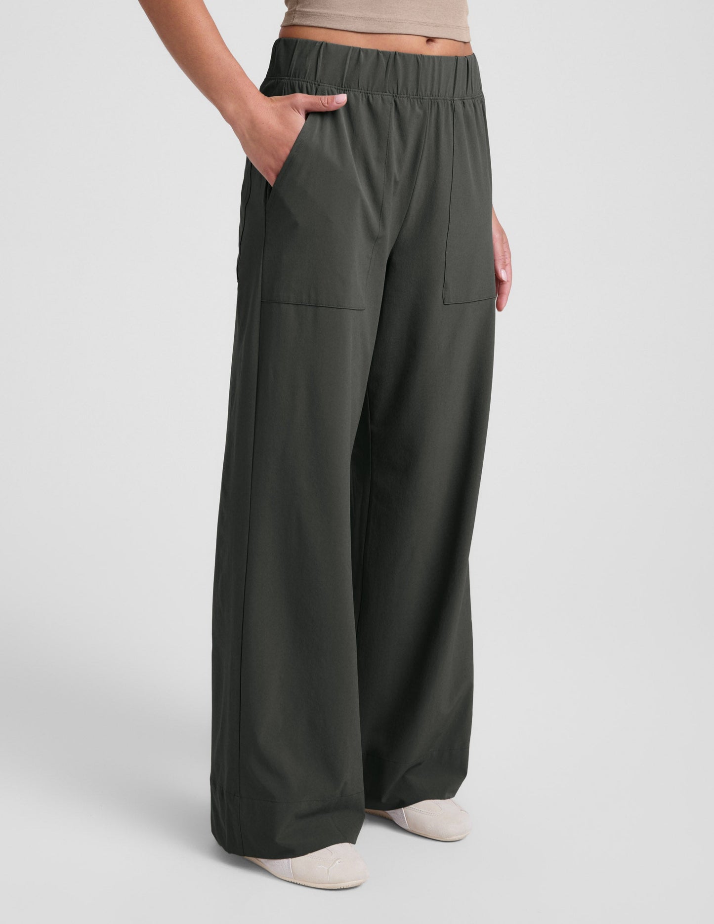 A person wears the dark olive Easy Wide Leg Pant 31" with a relaxed fit, wide leg, elastic waist, and side pockets.
