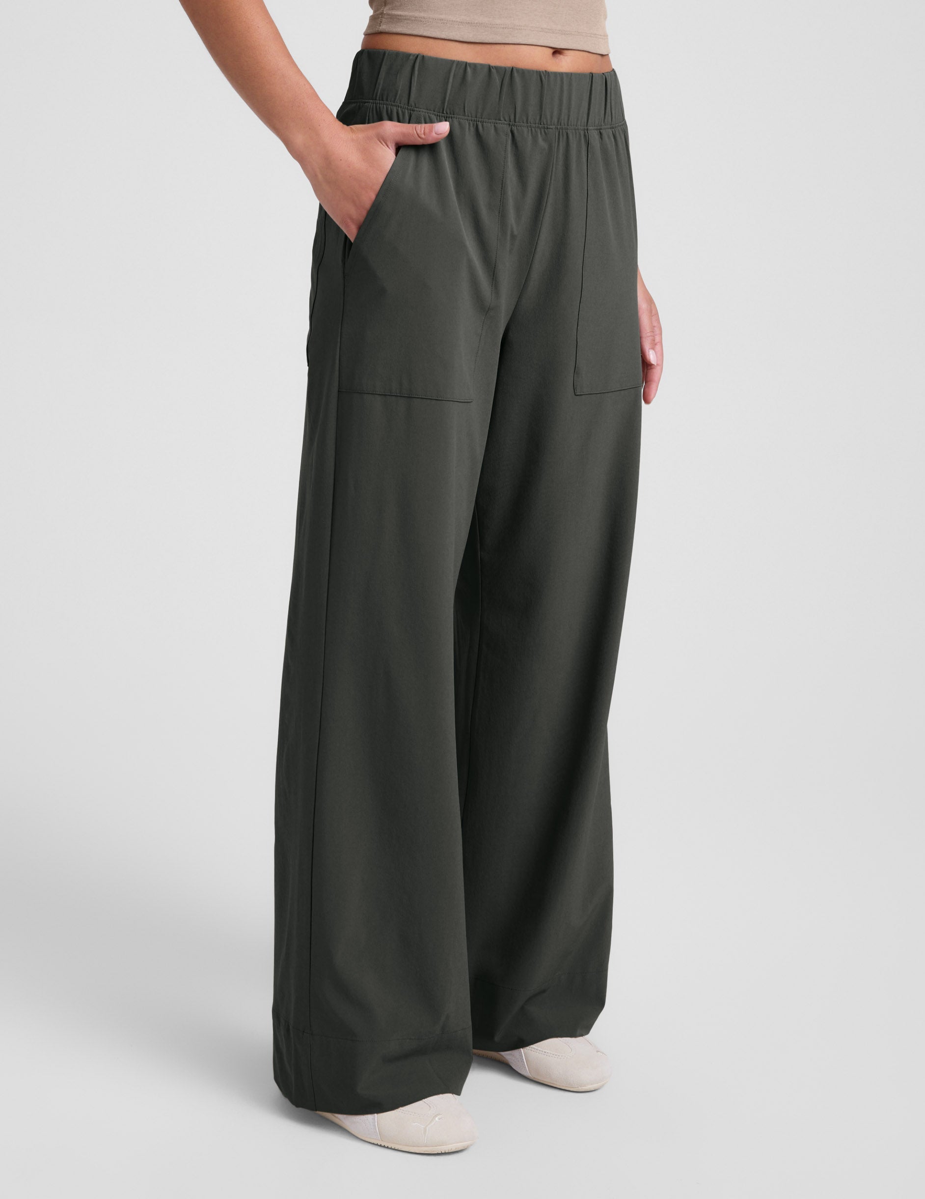 A person wears the dark olive Easy Wide Leg Pant 31" with a relaxed fit, wide leg, elastic waist, and side pockets.