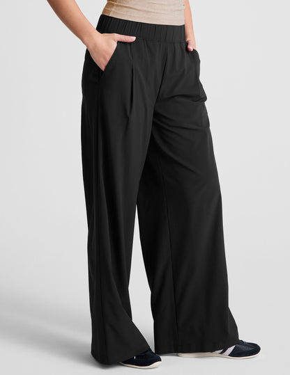 Black Easy Wide Leg 29" Pant with elastic waist, front pleats and side pockets shown in a flowy, relaxed fit on a model.