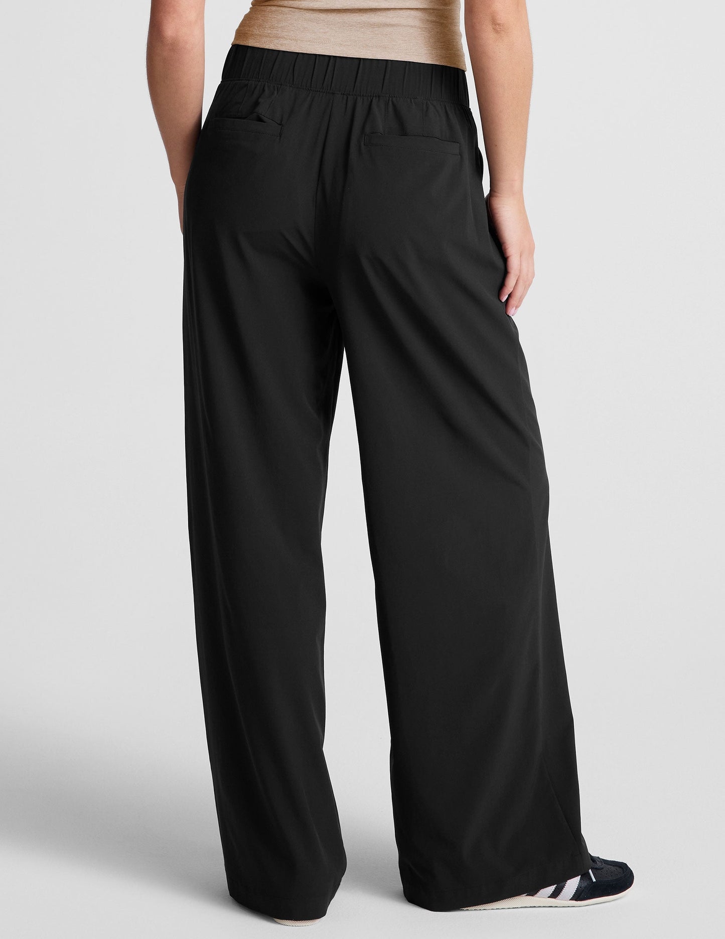 Back view of the Easy Wide Leg 29" Pant in black, featuring a gathered elastic waistband and two back welt pockets.