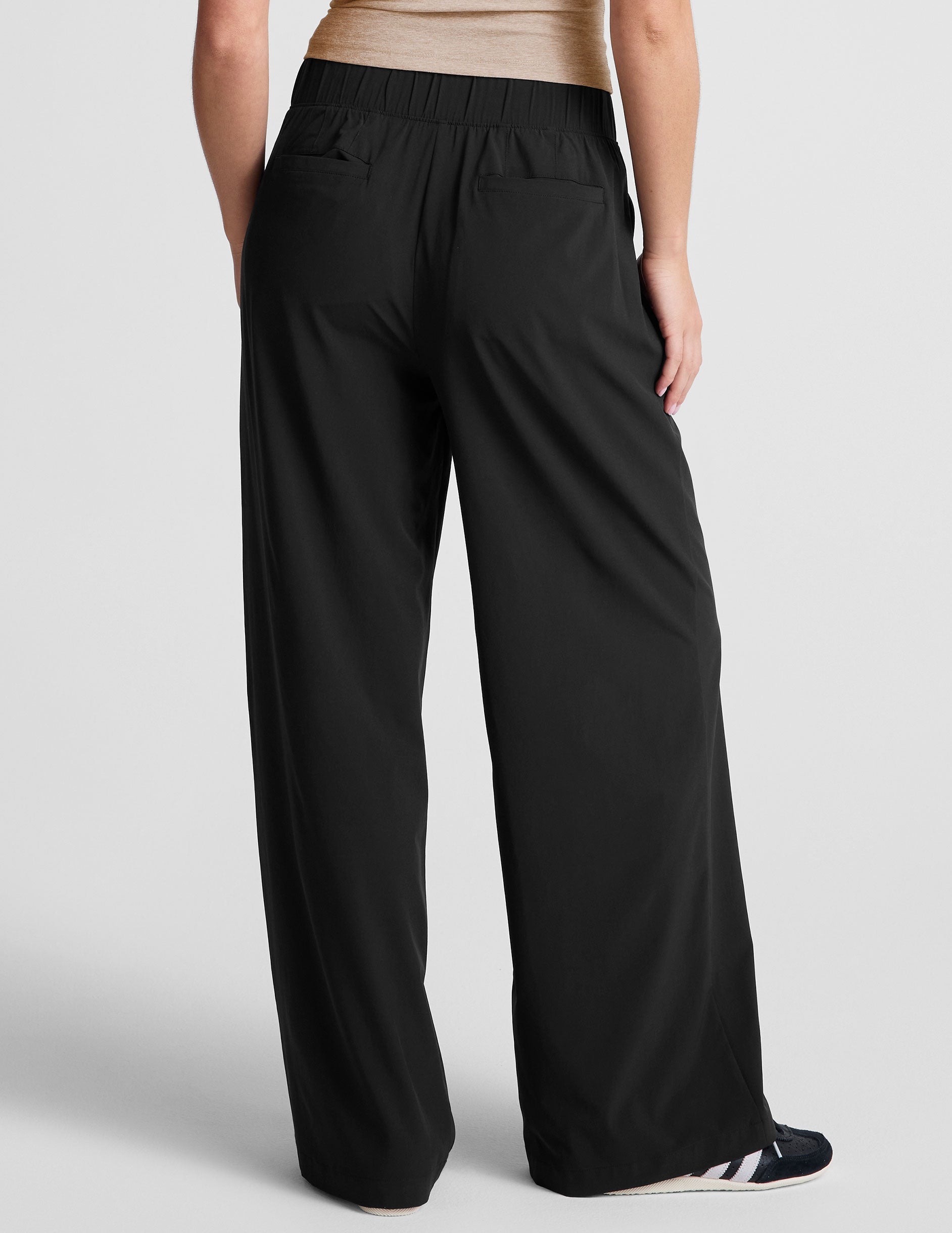 Back view of the Easy Wide Leg 29" Pant in black, featuring a gathered elastic waistband and two back welt pockets.
